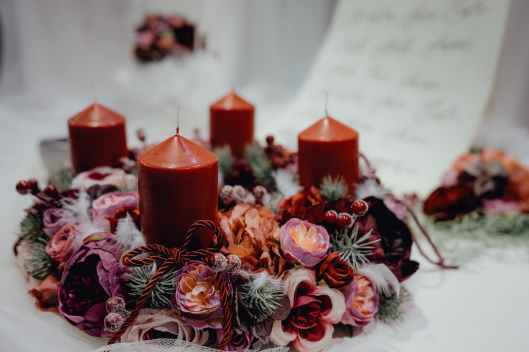 four red pillar candles on white surface