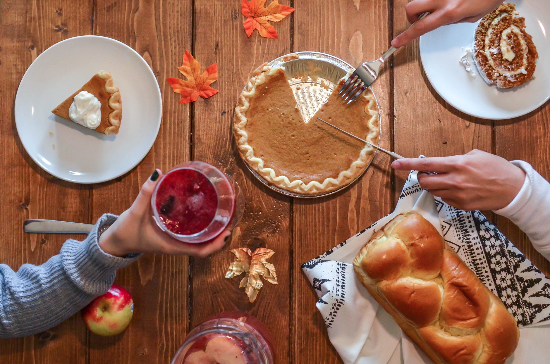person slicing pie on aluminum plate