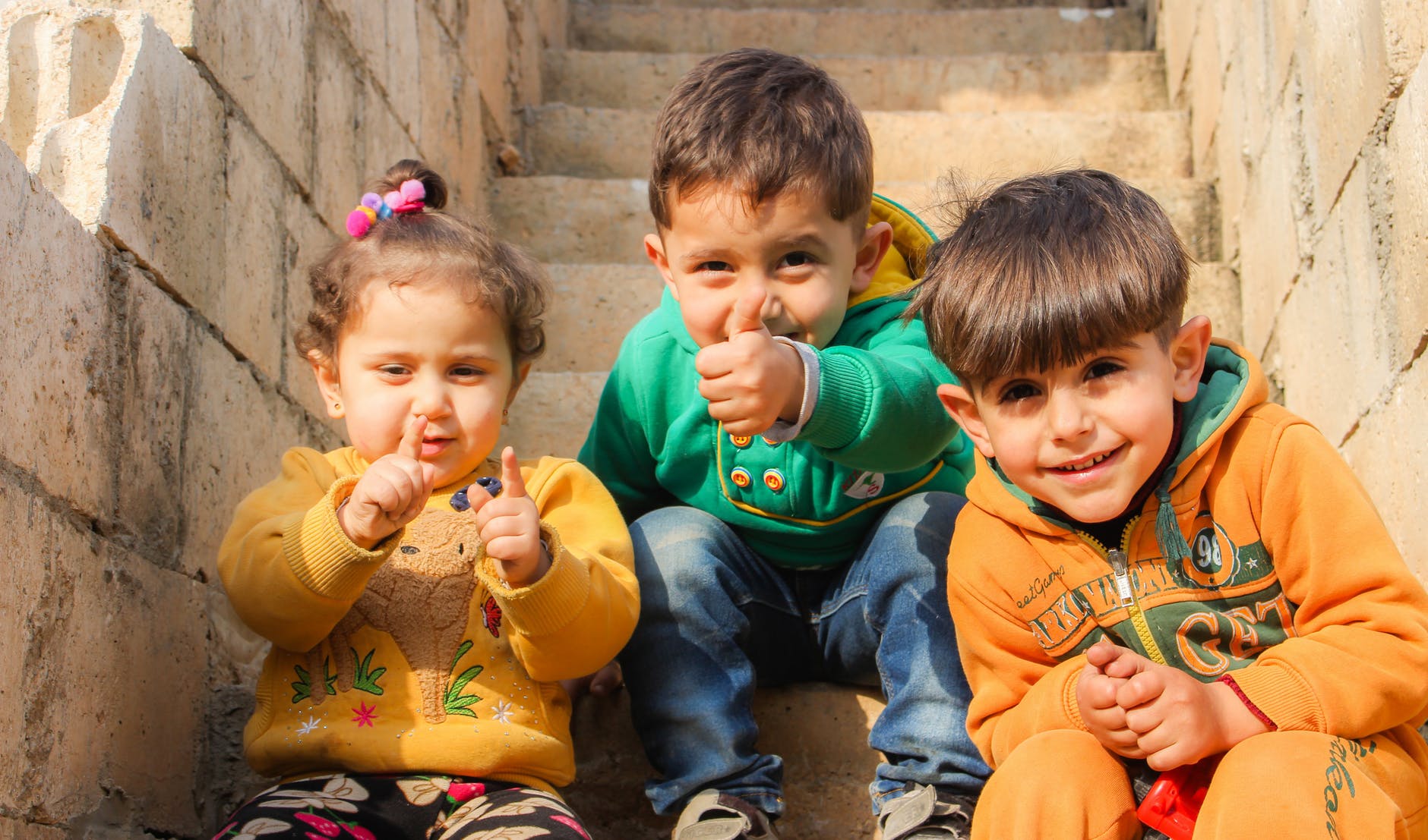 three children sitting on stairs
