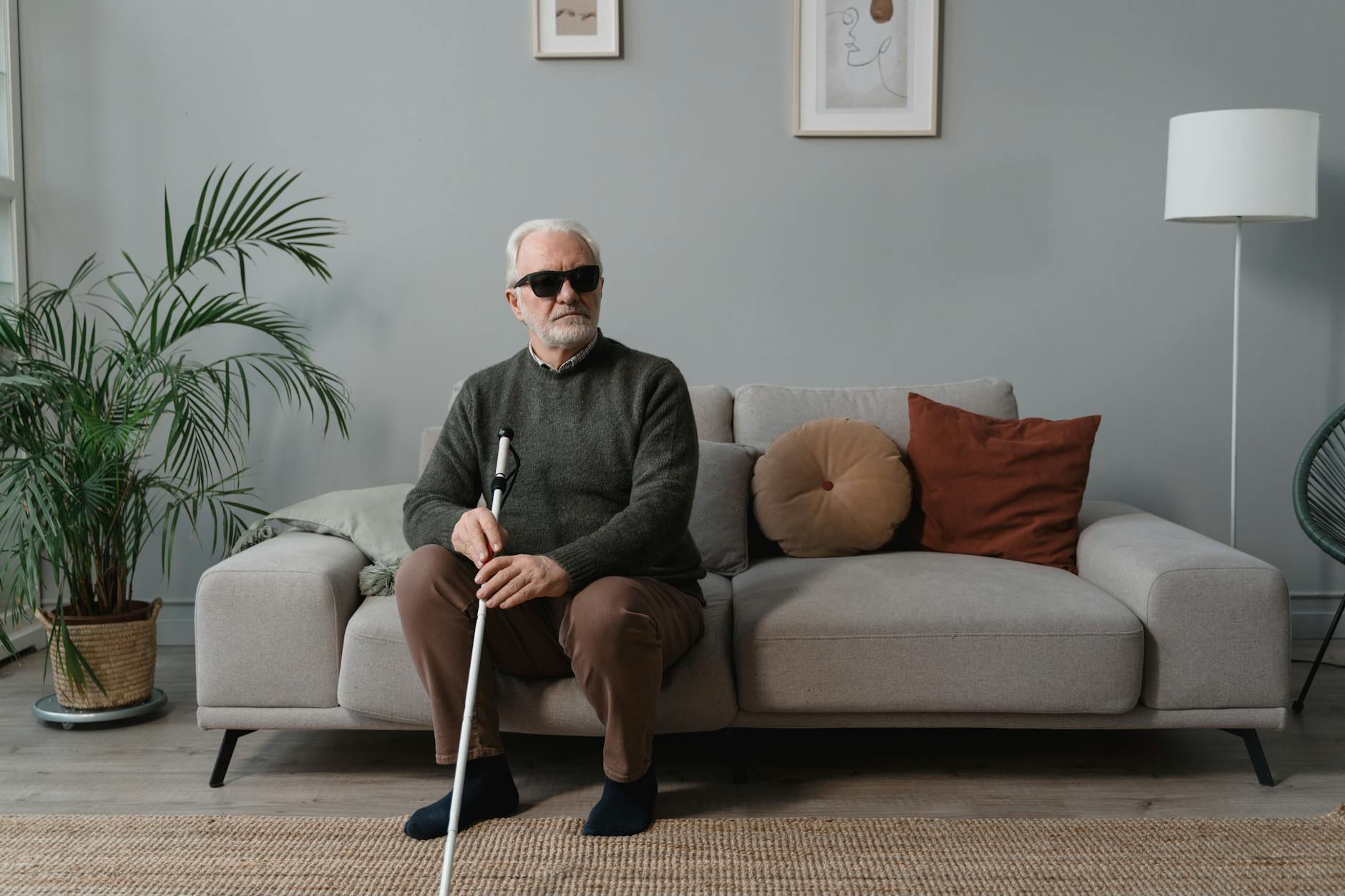 a blind man wearing sunglasses while holding his white cane